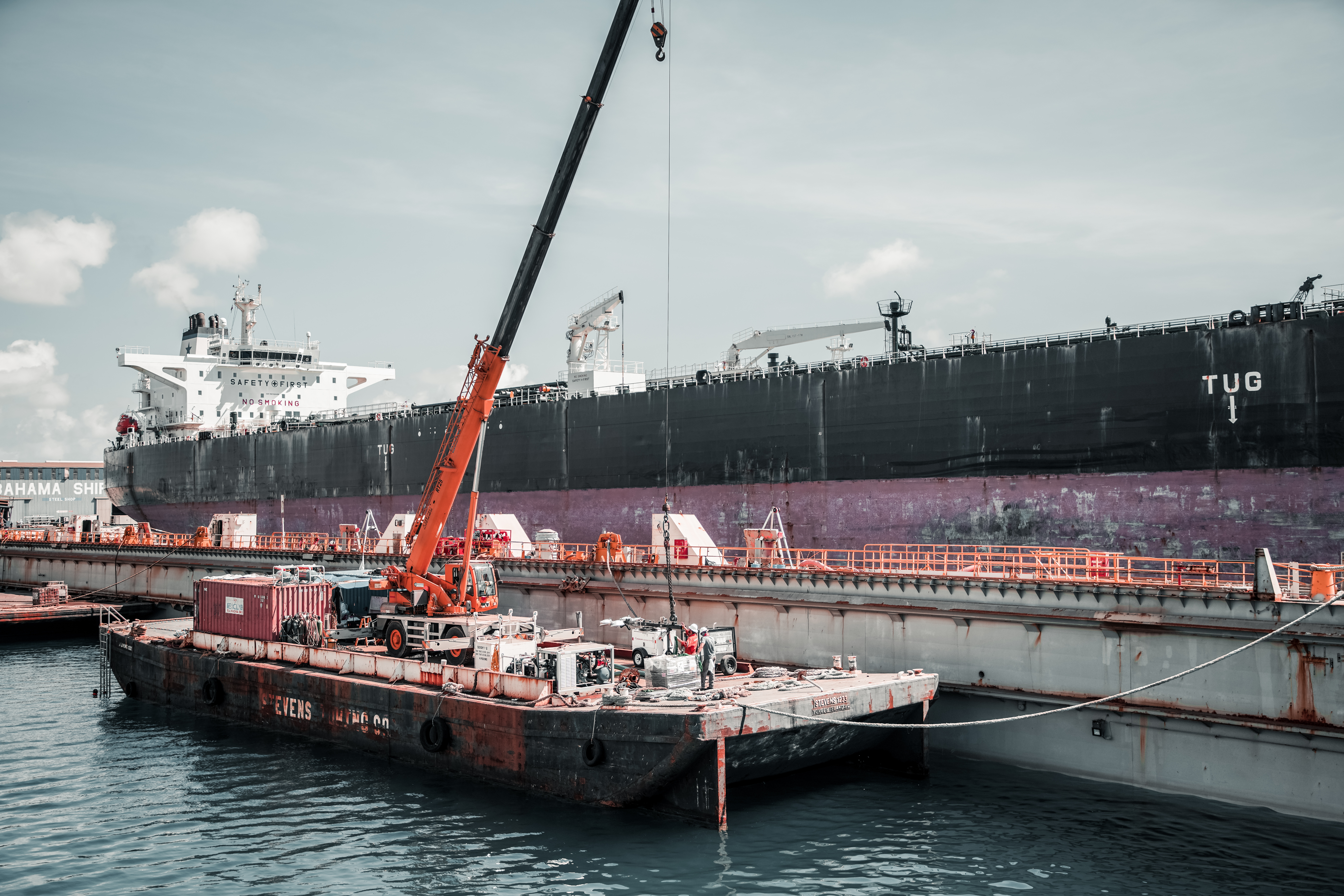 Two barges are docked to a dry dock on either side